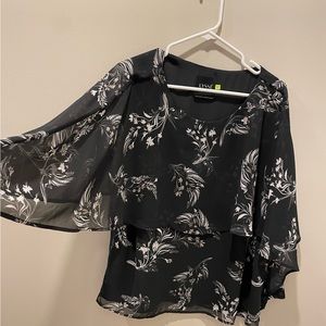 Layered, flowing top with open sleeves.